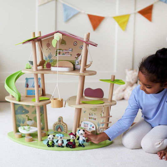 Child playing with a wooden toy set in a room with colorful flags on the wall.