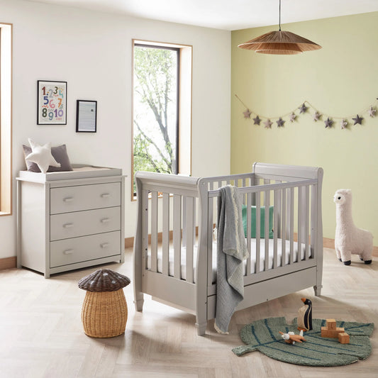 Nursery room with a crib, changing table, and decorative items.