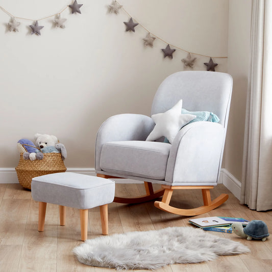 Gray rocking chair with ottoman in a nursery setting with toys and decorations.