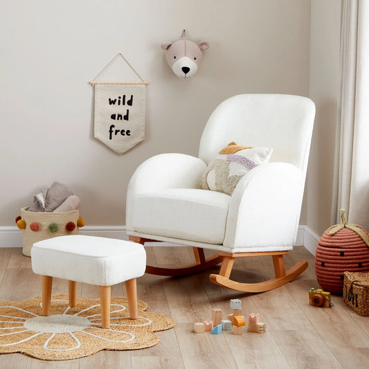 White rocking chair with ottoman in a child's room with toys and decor.