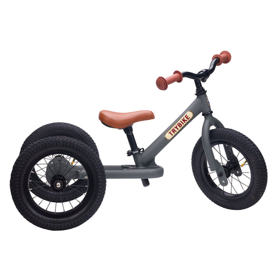 Children's tricycle with brown seat and handlebar on a white background