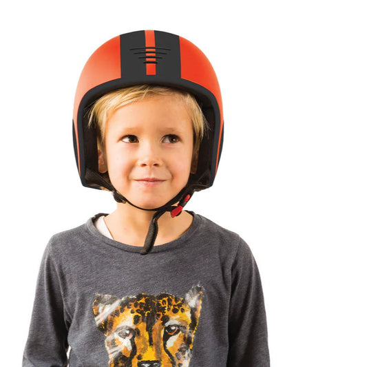 Child wearing an orange and black helmet on a white background