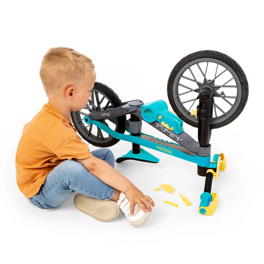 Child playing with a toy bike structure on a white background