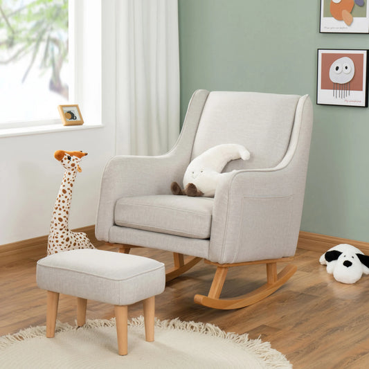 Gray rocking chair with ottoman and plush toys in a room with green walls and a window.