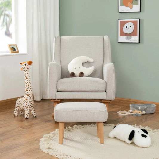 Gray armchair with ottoman in a room with toys and framed pictures on the wall.