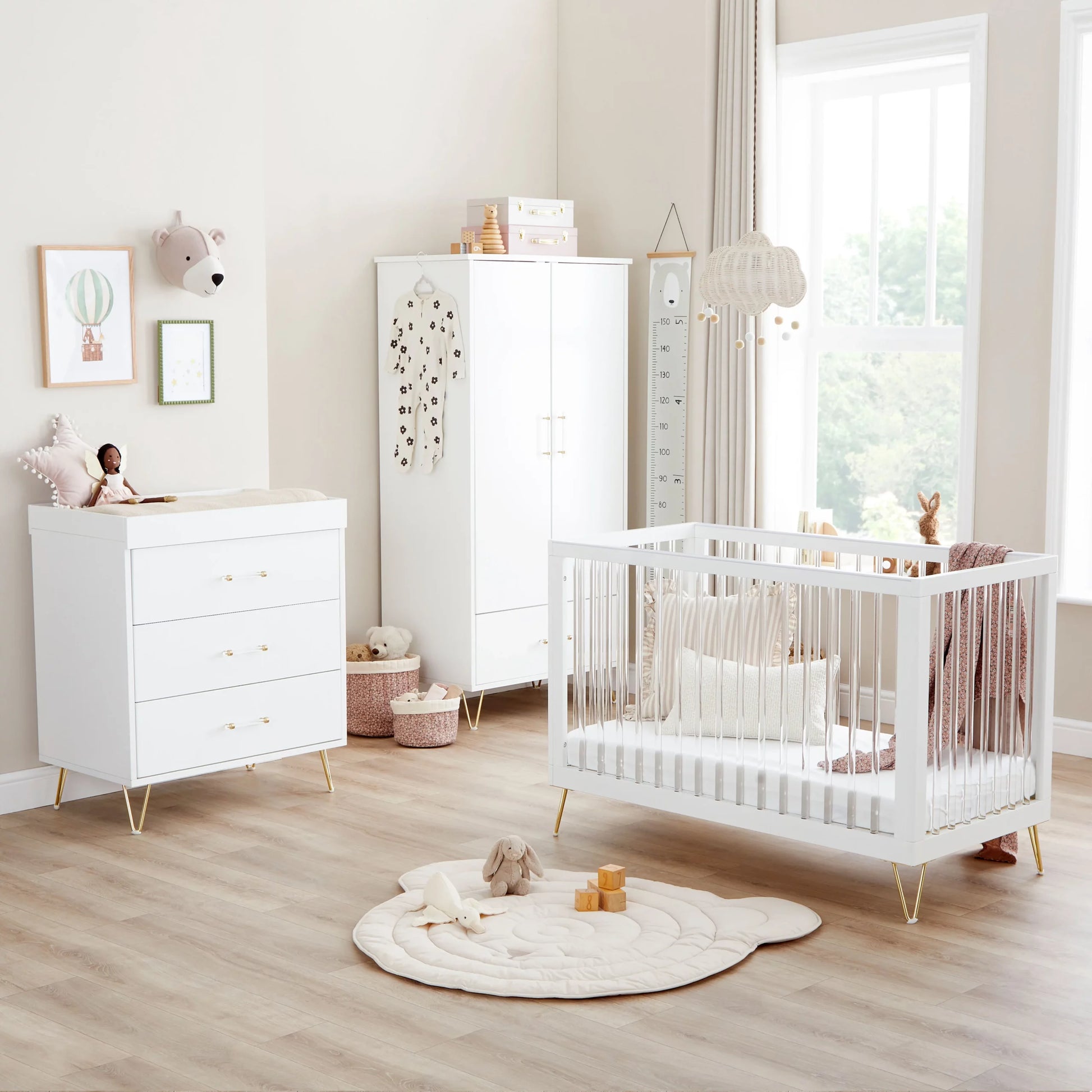 Nursery room with white crib, dresser, and wardrobe.
