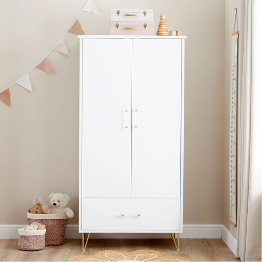 White wardrobe with gold legs in a child's room with toys and decor.