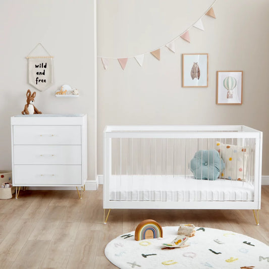 Nursery room with white crib, dresser, and decorative elements.