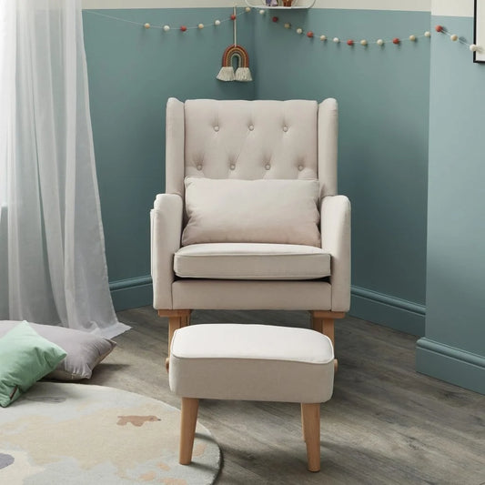 Beige armchair with matching ottoman against a teal wall