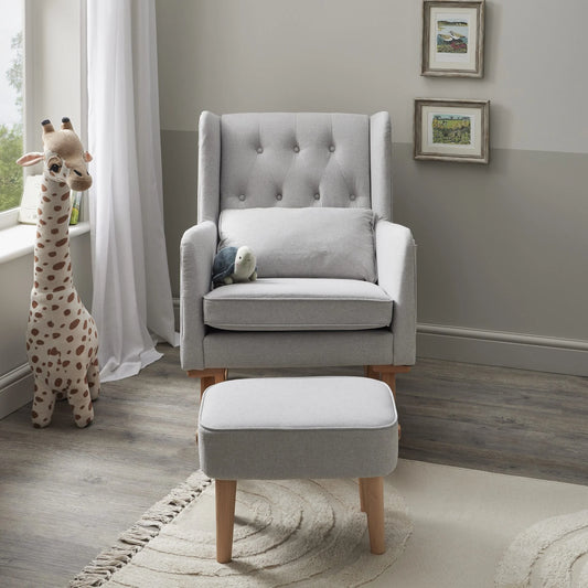 Gray upholstered rocking chair with ottoman in a nursery setting