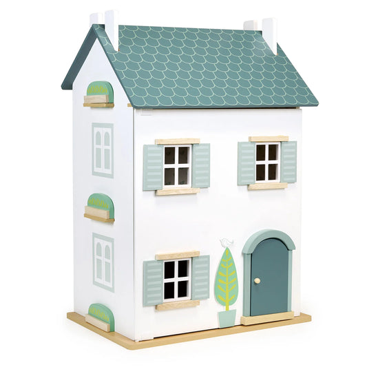 Toy dollhouse with a green roof and white walls on a white background