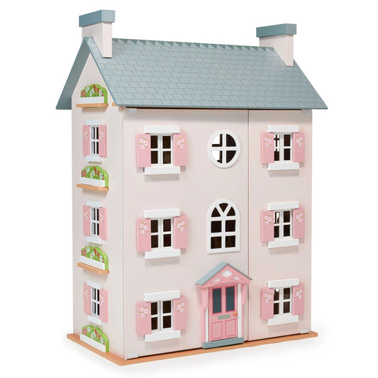 Wooden dollhouse with pink shutters and a gray roof on a white background