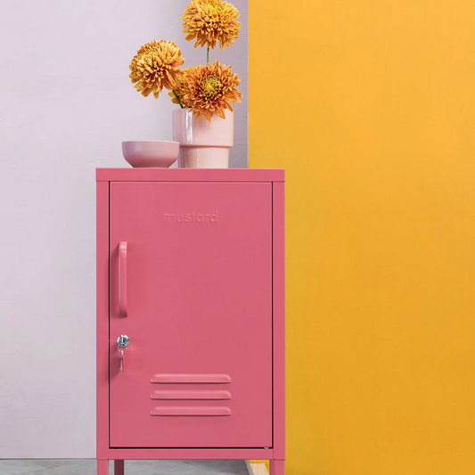 Pink metal locker with flowers against a colorful wall