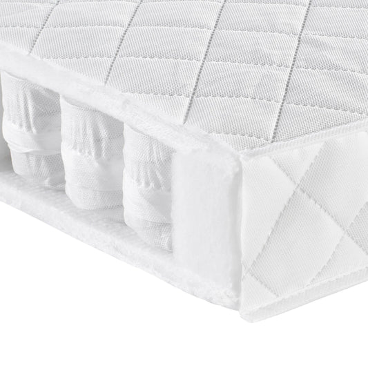 White quilted mattress protector on a bed with a white background