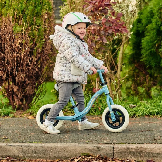 Child on balance bike wearing helmet 