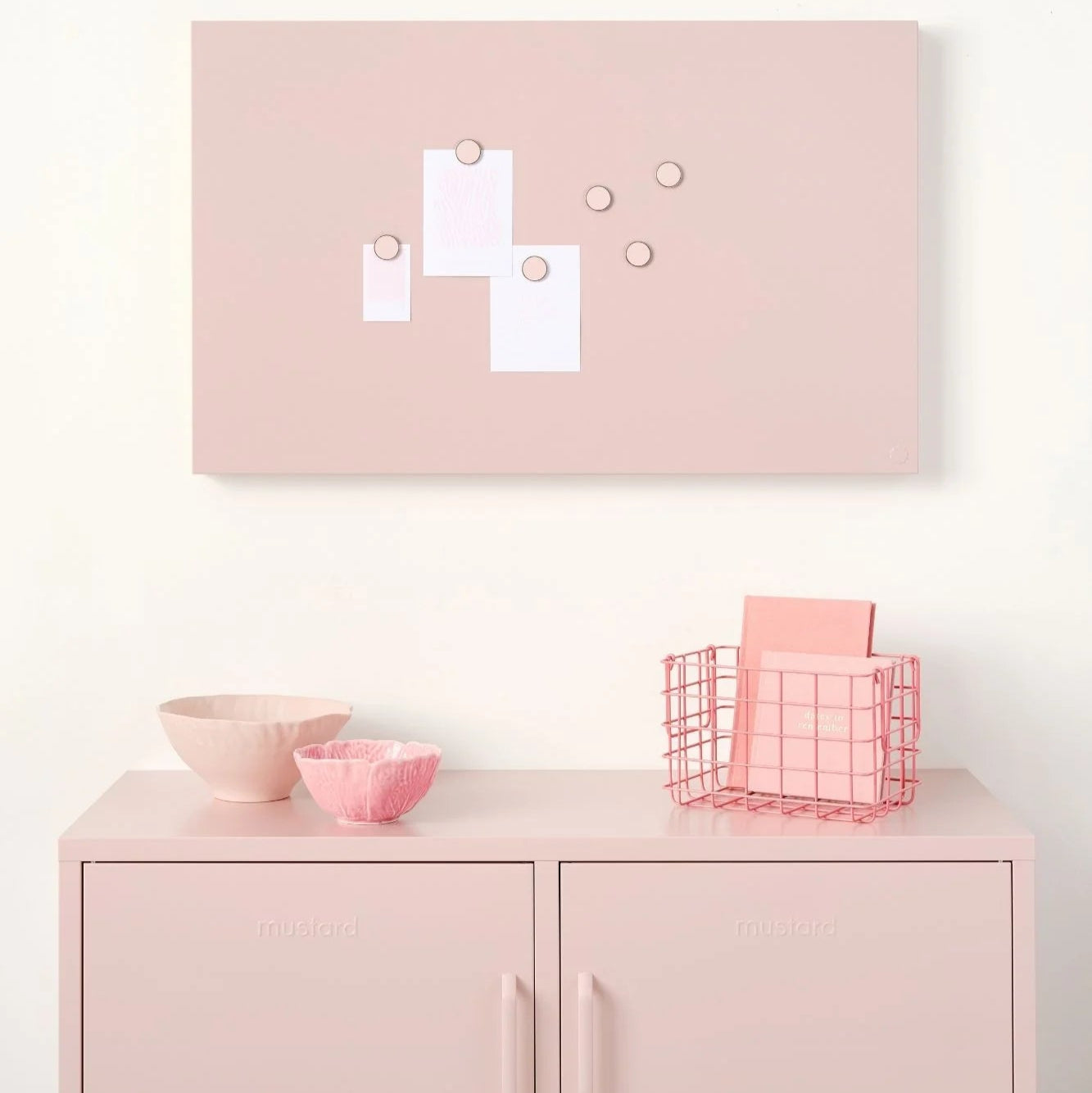 Pink cabinet with decorative items against a white wall