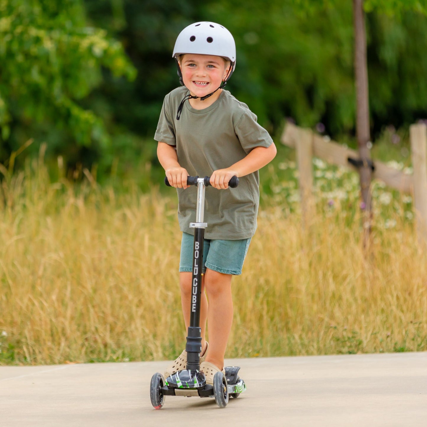 Child riding a scooter outdoors with a helmet on
