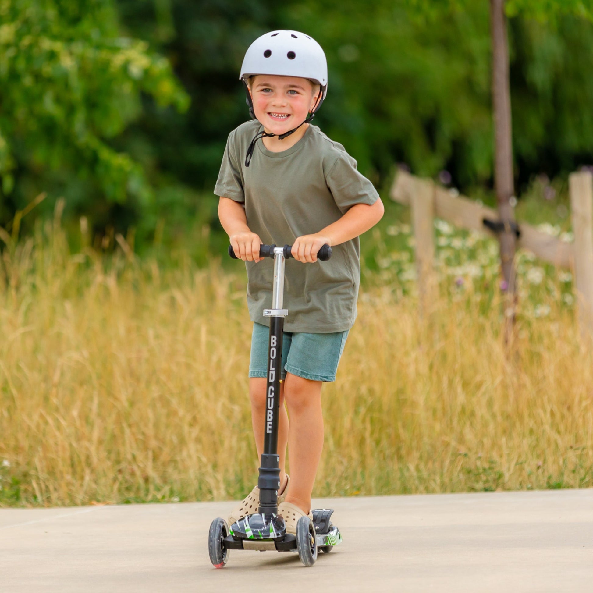 Child riding a scooter outdoors with a helmet on