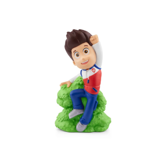 Toy figure of a character sitting on a green rock with a white background