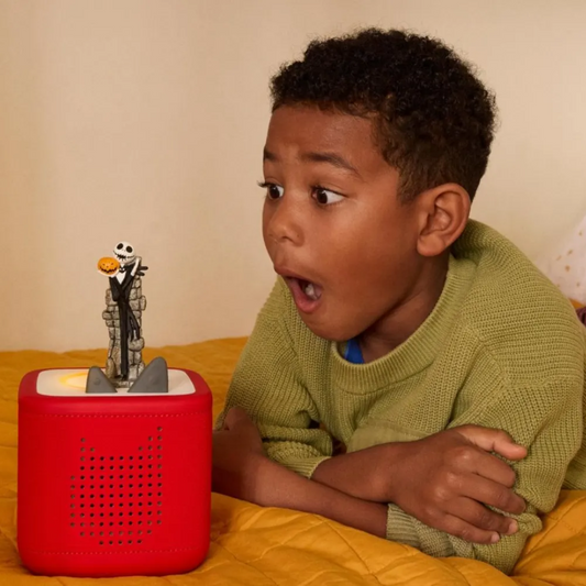 Child with a red toy figure on a yellow blanket