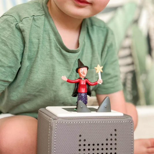 Child playing with a toy figure on a small electronic device