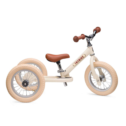 Children's tricycle with beige body and brown seat and handlebar on a white background