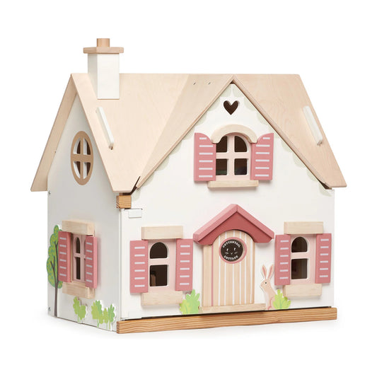 Wooden toy house with pink shutters and a white base on a white background