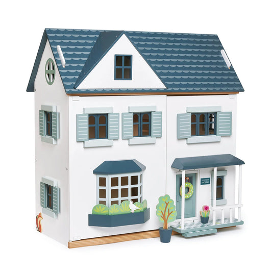 Toy dollhouse with blue roof and white walls on a white background