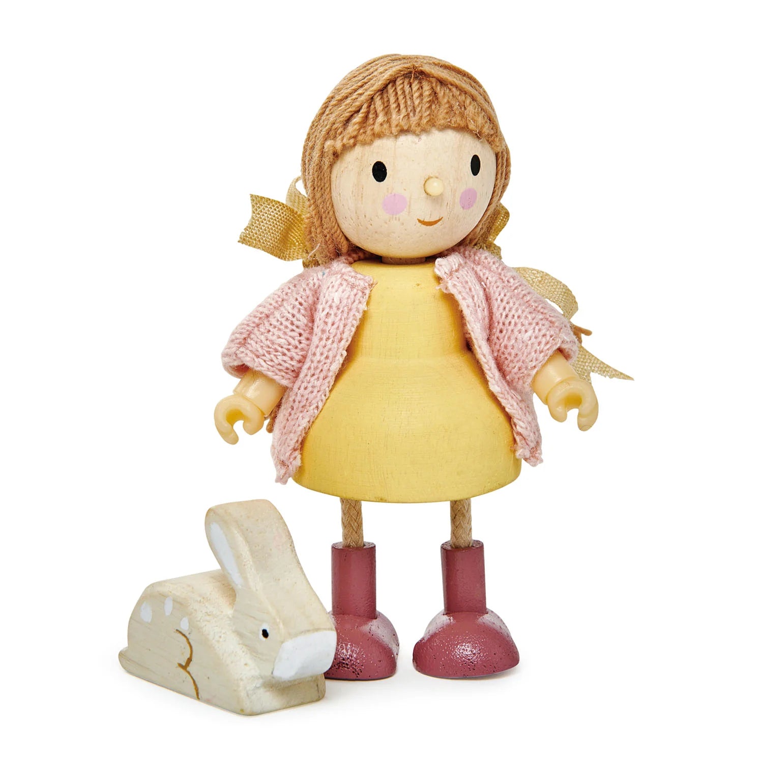 Toy doll with a yellow dress and pink scarf, standing next to a wooden rabbit toy on a white background.