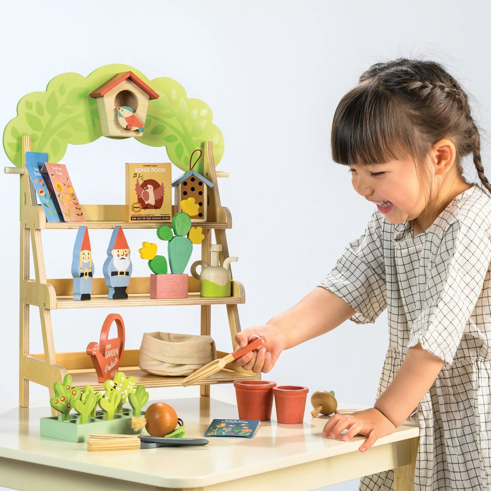 Child playing with a toy garden set on a table
