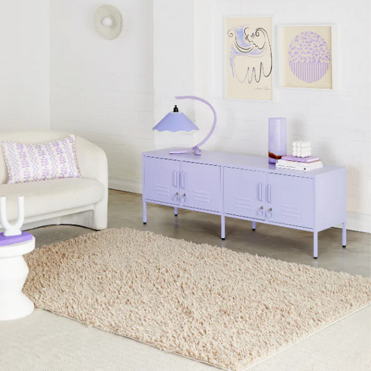 Modern living room with a lavender sideboard, white sofa, and decorative items.