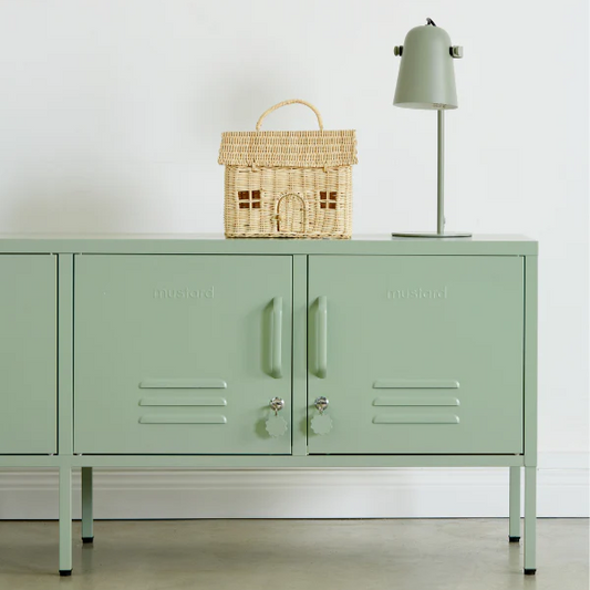 Green cabinet with decorative items on a white wall