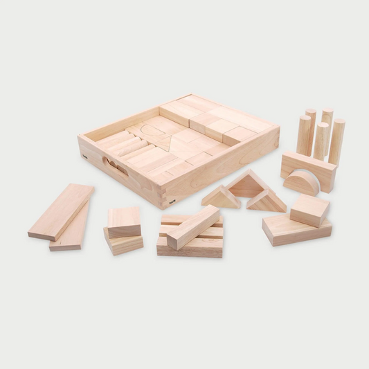 Set of wooden building blocks with a storage box on a light gray background