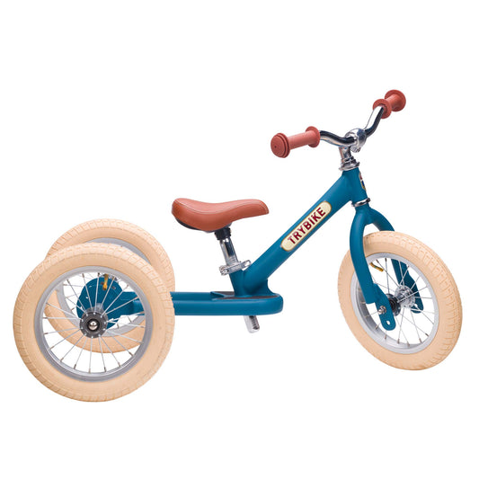 Blue balance bike with beige tires and red handlebar on a white background