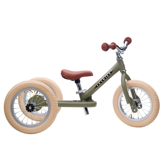 Children's balance bike with beige tires and red handlebar grips on a white background