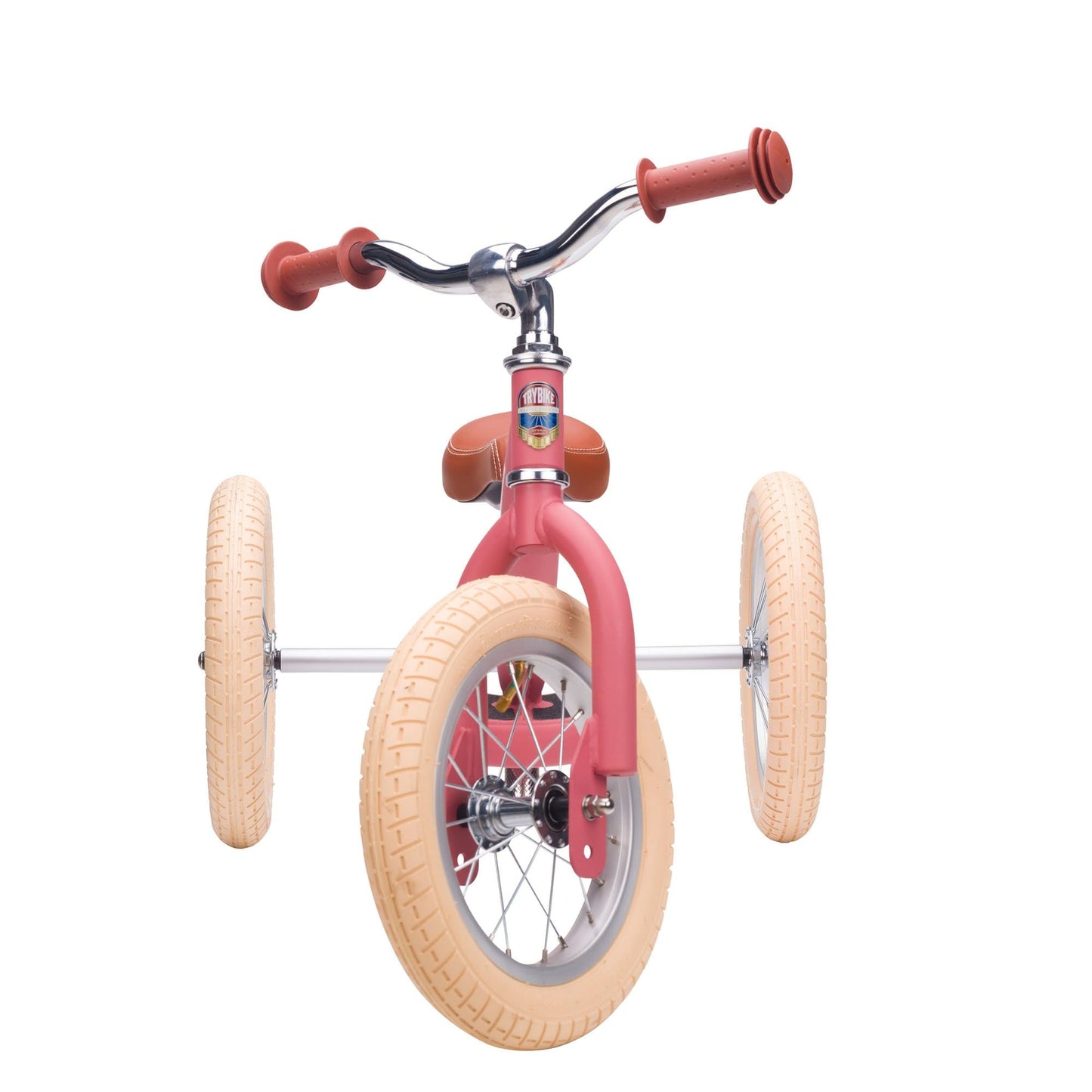 Pink balance bike with tan wheels on a white background