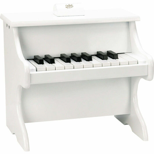 White wooden toy piano on back background