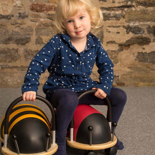 Child sat on a ladybug ride on toy