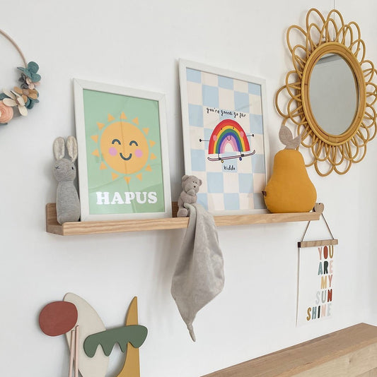 Children's room decor with shelves, toys, and wall art on a white wall.