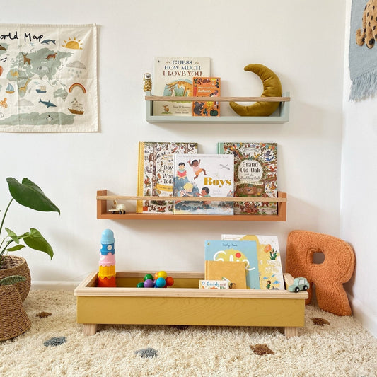 Children's room with shelves, books, and toys on a carpeted floor.