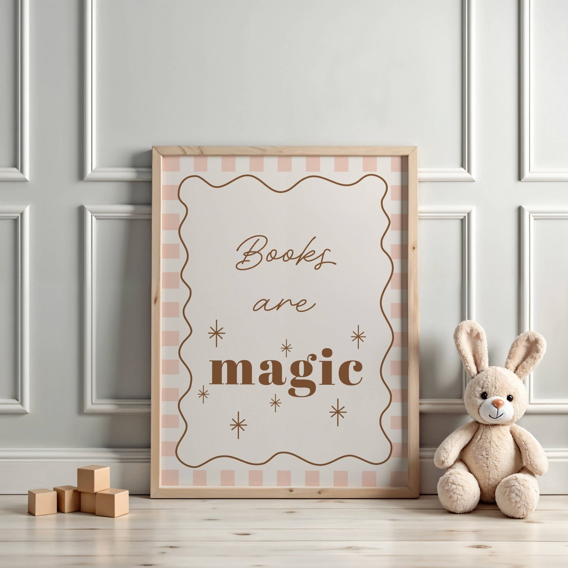 Framed poster with 'Books are magic' text on a wall with a teddy bear and wooden blocks.