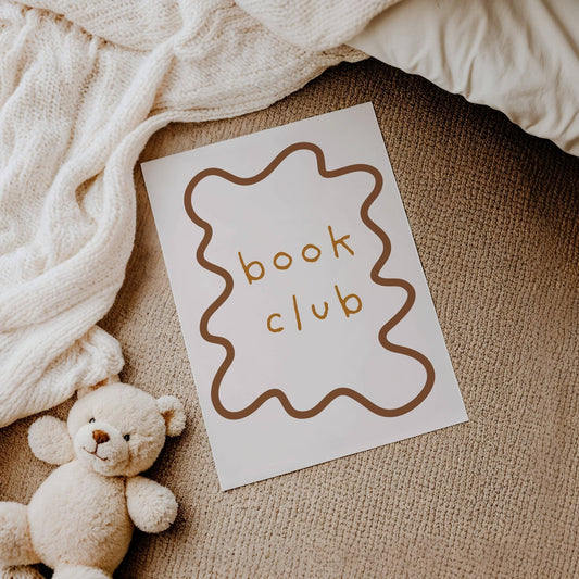 Card with 'book club' text next to a teddy bear on a textured surface