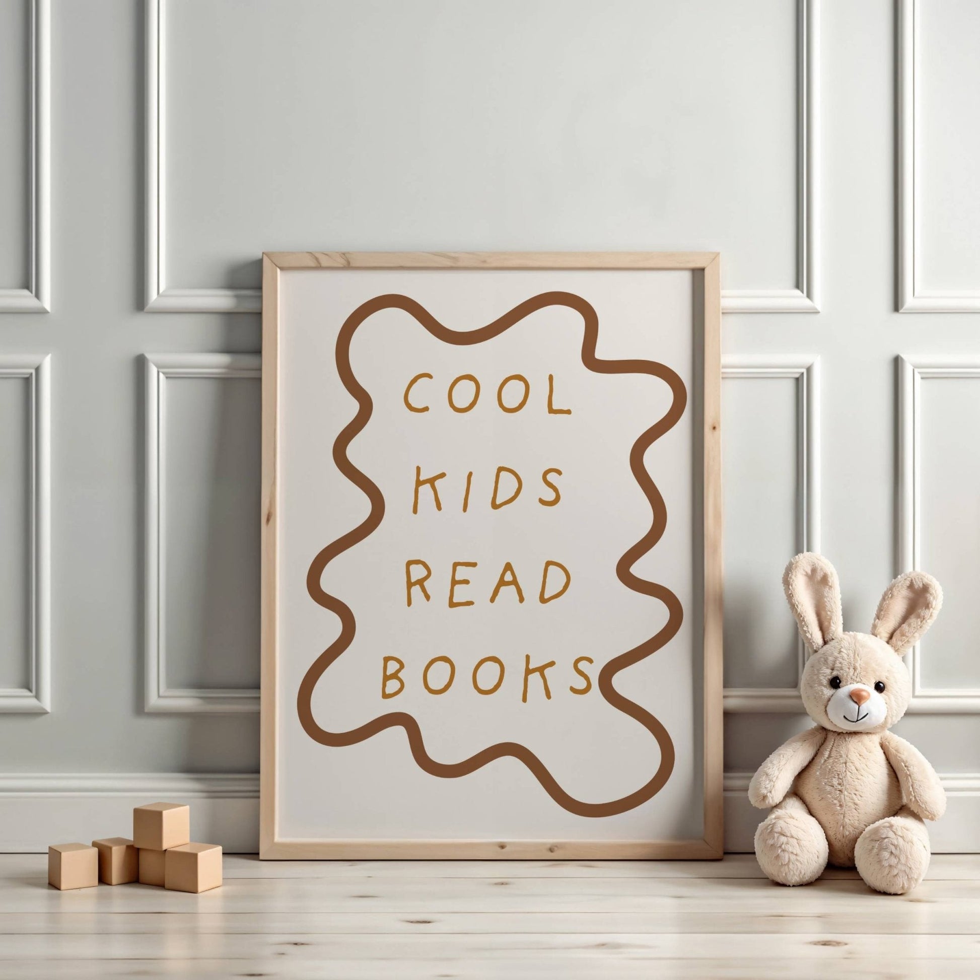Framed poster with 'Cool kids read books' text on a wall with a teddy bear and wooden blocks.