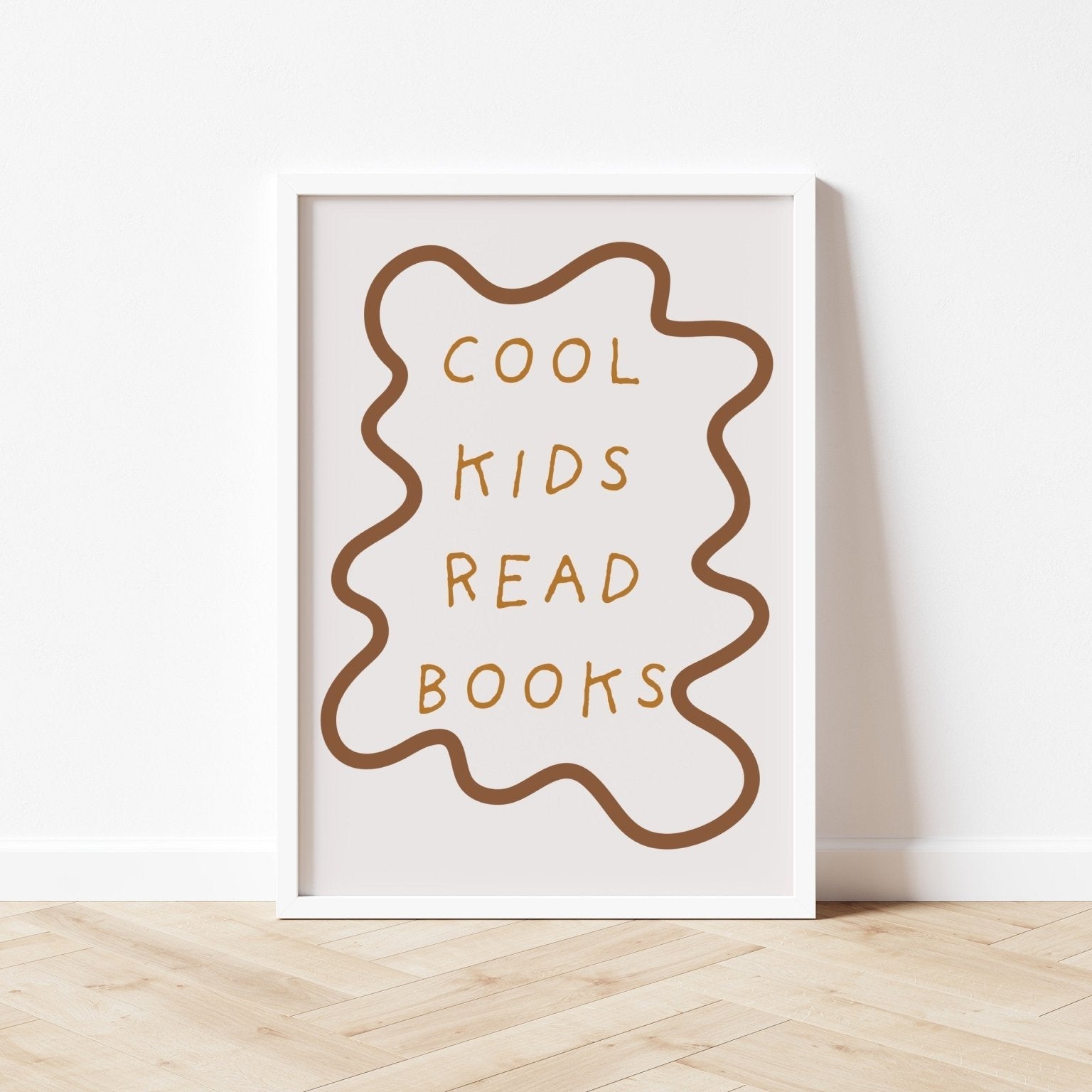 Framed poster with 'Cool kids read books' text on a white wall.