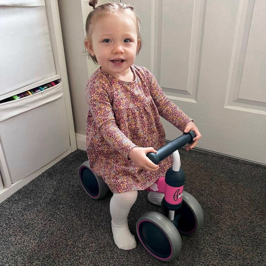 Child with a tricycle indoors