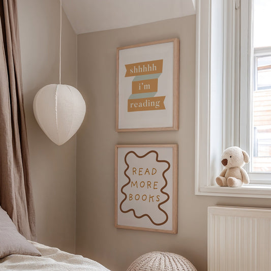 Children's room with framed quotes on the wall and a teddy bear by the window.