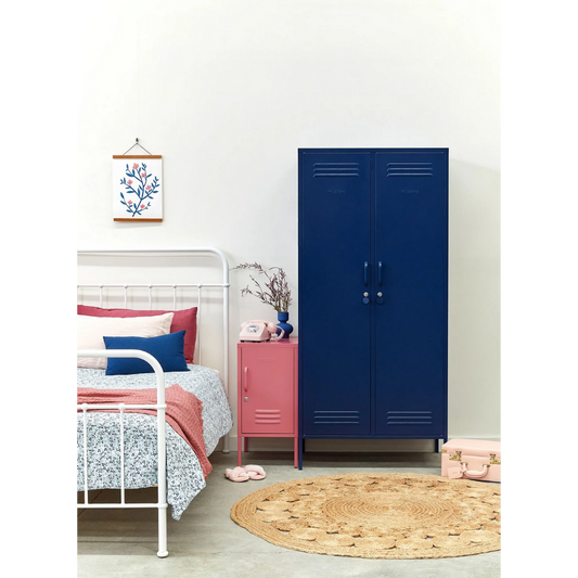 Children's bedroom with a blue locker, pink dresser, and white bed.