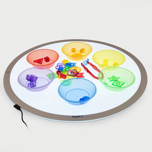 Round light-up tray with colourful compartments and toys on a white background