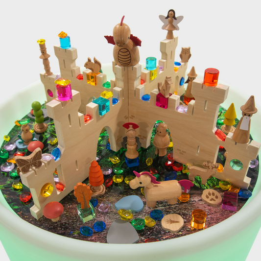 Toy castle with figurines and colorful blocks on a sensory light table