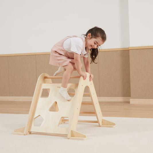 Child playing with a wooden climbing frame.
